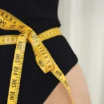 A measuring tape on a woman's waist.