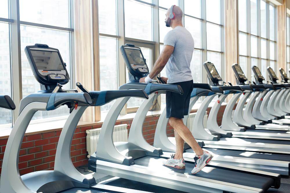 Man in a gym, treadmill.